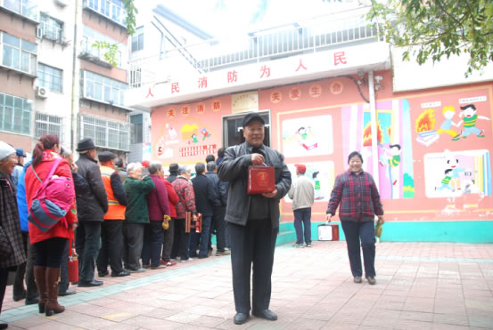圖4 領到干粉滅火球的老人感謝大家的愛心